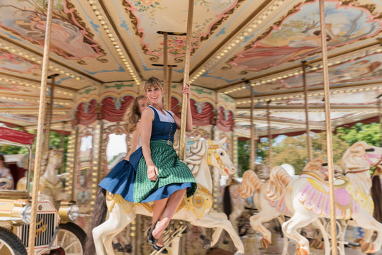 Sch&ouml;ne Frau im Dirndl f&auml;hrt Karrussell