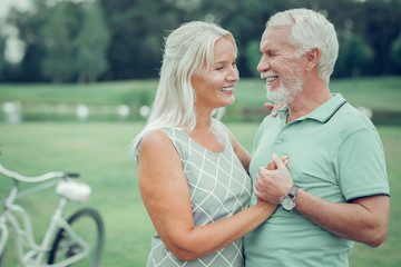 Delighted good looking aged couple standing together