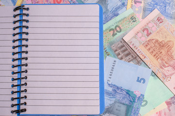 Hryvnia paper bill and notebook, free space. Notes in denominations of one, two, five, ten and...