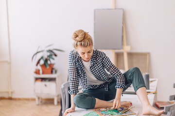 woman creates masterpiece. full lenth photo.painter arranges and mixes paints.art therapy