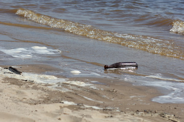 Empty bottle on the beach littering the environment