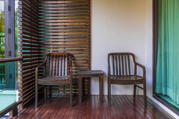 Vintage two seats table set at balcony. It consists of armchairs and small table.