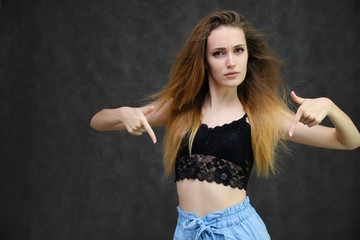 Photograph of a portrait of a beautiful girl woman with long dark flowing hair, happy life on a dark gray background. She is standing directly in front of the camera in various poses and smiling.