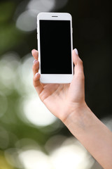 Young woman with mobile phone outdoors