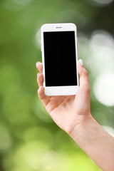 Young woman with mobile phone outdoors