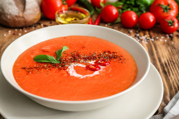 Bowl of tasty tomato cream soup on table