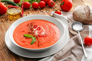 Bowl of tasty tomato cream soup on table