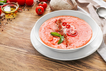 Bowl of tasty tomato cream soup on table