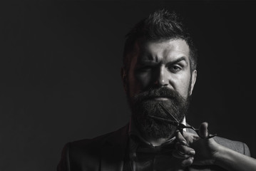 Barber scissors and straight razor, barbershop. Mens haircut, shaving. Bearded man, long beard, brutal, caucasian hipster with moustache. Vintage barbershop.