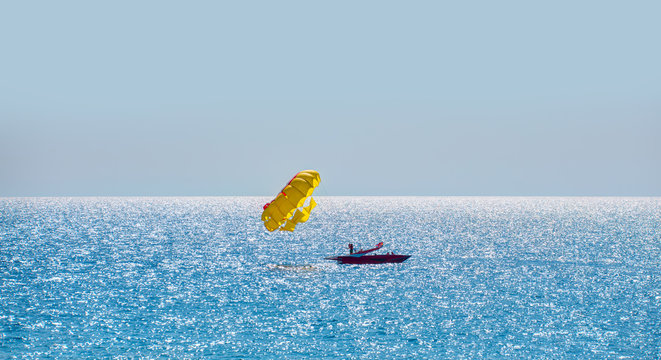 Yellow parasail wing pulled by a boat in the sea water - Alanya, Turkey