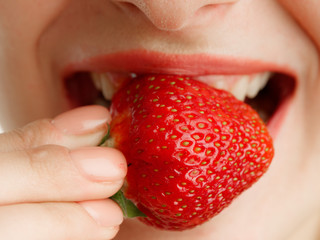 female mouth with teeth strawberry berries on a white background
