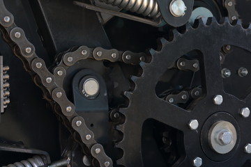 Transmission agricultural machinery. Sprockets, chain drives and springs are visible. Close-up.