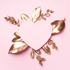 Golden leaves, heart shaped paper on pink background with copy space. Top view. Copy space. Summer...