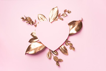 Golden leaves, heart shaped paper on pink background with copy space. Top view. Copy space. Summer...