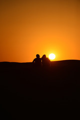 Silhouettes at sunset in the Arabian desert 