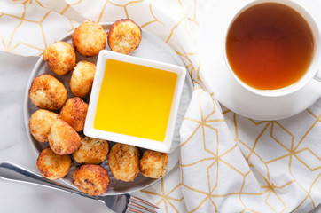 Top view of table set for tasty breakfast. Fried cheese and dough balls with honey.Sweet cheese balls