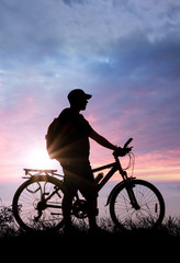 Obraz premium Concept of an active lifestyle. Silhouette of cyclist at sunset
