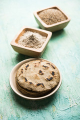 Bajra (pearl millet) / sorghum grains with it's flour or powder in a bowl, selective focus