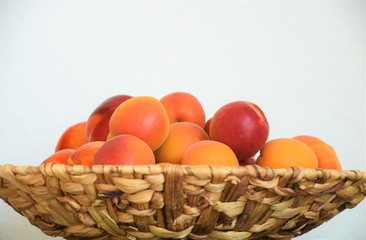 ripe apricots and nectarines in a wicker basket