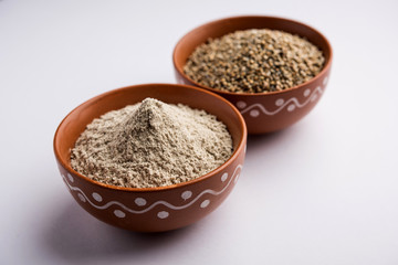 Bajra (pearl millet) / sorghum grains with it's flour or powder in a bowl, selective focus