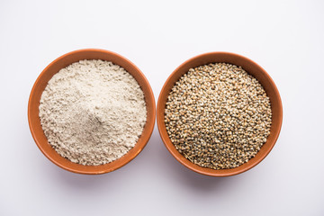 Bajra (pearl millet) / sorghum grains with it's flour or powder in a bowl, selective focus