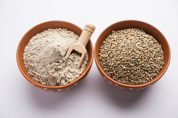 Bajra (pearl millet) / sorghum grains with it's flour or powder in a bowl, selective focus