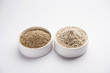 Bajra (pearl millet) / sorghum grains with it's flour or powder in a bowl, selective focus