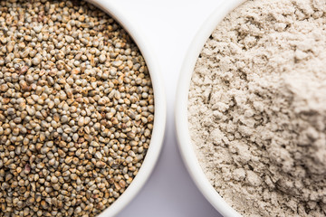 Bajra (pearl millet) / sorghum grains with it's flour or powder in a bowl, selective focus