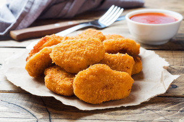 chicken nuggets with tomato sauce on wooden background. Copy space.