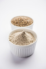 Bajra (pearl millet) / sorghum grains with it's flour or powder in a bowl, selective focus
