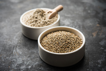 Bajra (pearl millet) / sorghum grains with it's flour or powder in a bowl, selective focus