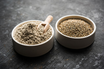 Bajra (pearl millet) / sorghum grains with it's flour or powder in a bowl, selective focus