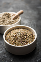 Bajra (pearl millet) / sorghum grains with it's flour or powder in a bowl, selective focus