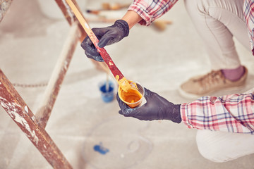 Working woman plastering / painting walls inside the house.