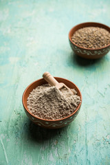 Bajra (pearl millet) / sorghum grains with it's flour or powder in a bowl, selective focus