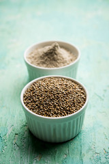 Bajra (pearl millet) / sorghum grains with it's flour or powder in a bowl, selective focus