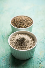 Bajra (pearl millet) / sorghum grains with it's flour or powder in a bowl, selective focus