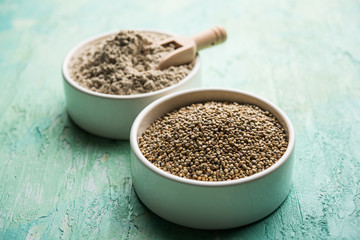 Bajra (pearl millet) / sorghum grains with it's flour or powder in a bowl, selective focus