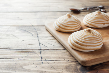 Vanilla marshmallow zephyr with caramel on a wooden table. Selective focus. Copy space.