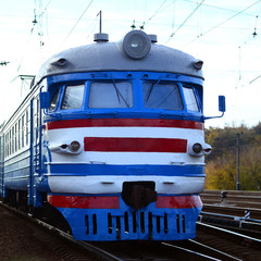 Old soviet electric train with outdated design moving by rail