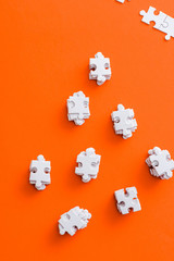 top view of stacks with white puzzle pieces on orange