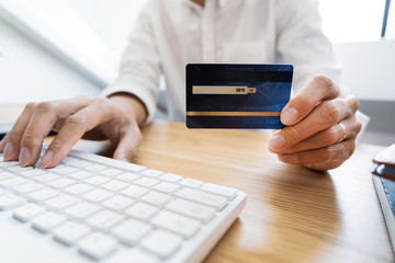 Man paying with credit card and entering security code for online shoping making a payment or purchasing goods on the internet with laptop computer, online shopping concept