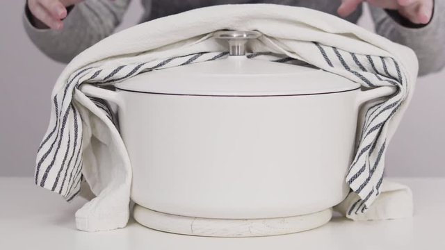 White enameled cast iron covered dutch oven on a white background.
