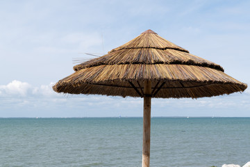 straw umbrella in the blue sky concept of holidays vacation