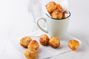 Cup full of fried sweet cheese balls on the baking paper.Sweet delicious snack