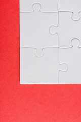 top view of white connected jigsaw puzzle pieces isolated on red