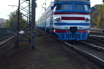 Old soviet electric train with outdated design moving by rail
