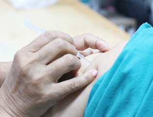Close up hand of doctor giving patient taking vaccine