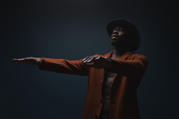 Fototapeta na wymiar Portrait of male singer in hat and coat. Artist, performer
