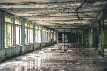 gloomy corridor with broken window frames and debris